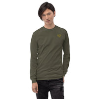 Model wearing a military green long sleeve t-shirt with a yellow glasses-face chest design