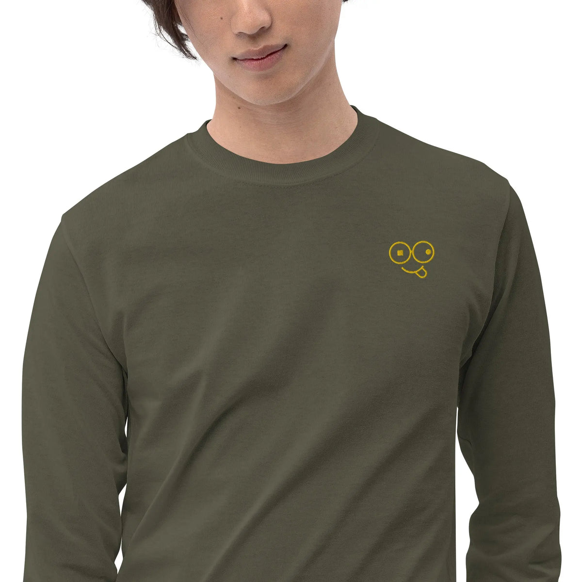 Close-up of a military green crew neck t-shirt showing the yellow tongue-out glasses-face chest design
