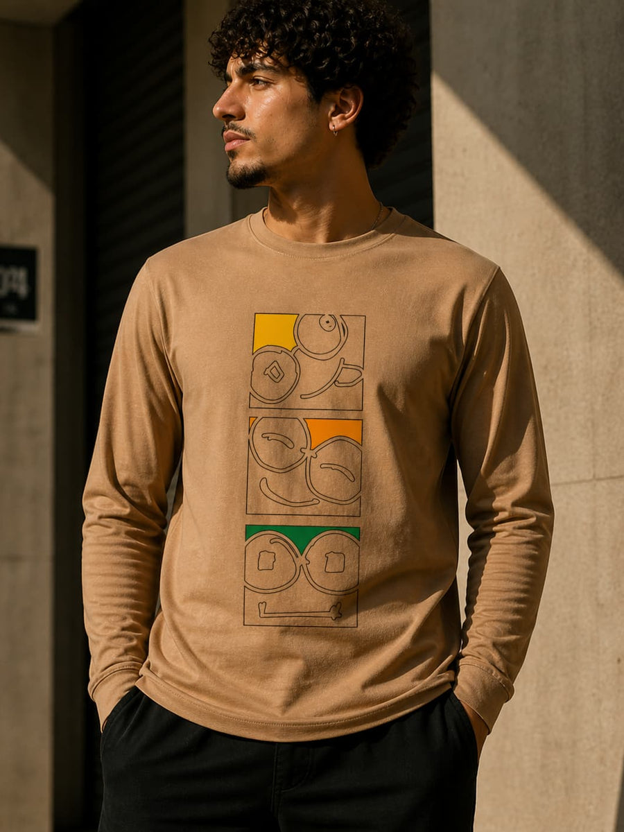 Model wearing a beige long sleeve t-shirt with three stacked glasses-face graphics and yellow, orange and green accents