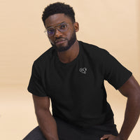 Close-up of a model wearing a black crew neck t-shirt with a white tongue-out glasses-face chest design