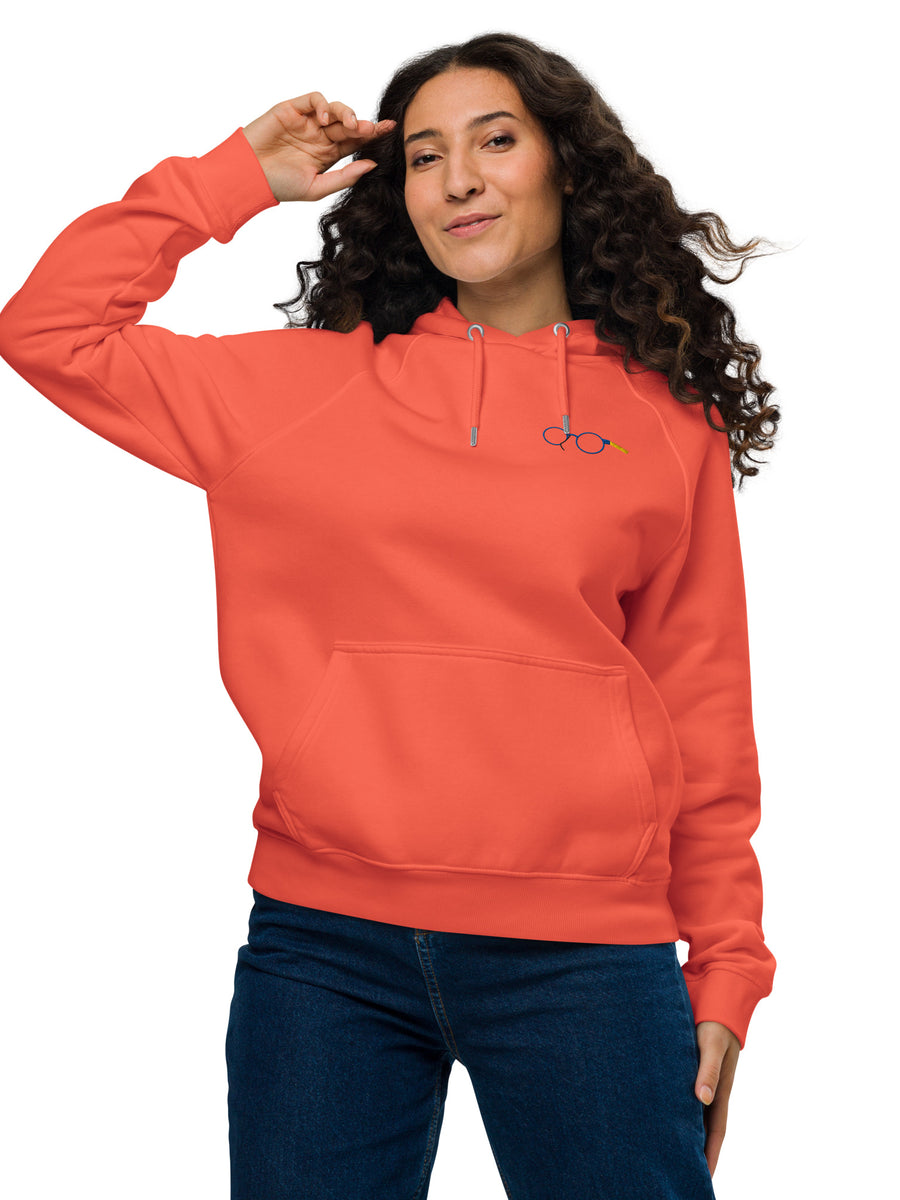 Model wearing an orange unisex raglan hoodie with glasses chest graphic, drawstring hood and kangaroo pocket