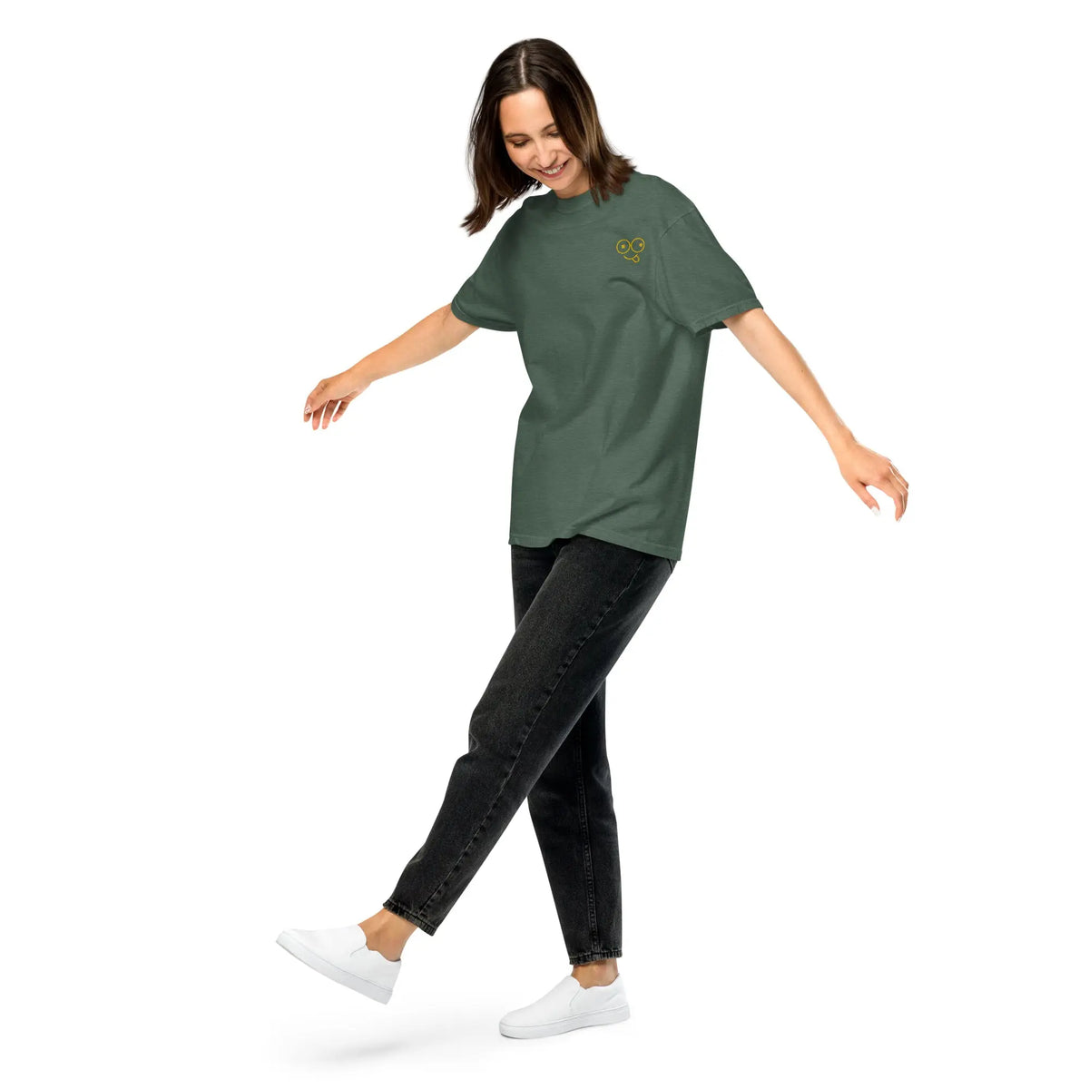 Model wearing a blue spruce green unisex t-shirt with a small yellow glasses-face chest design