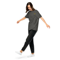 Model wearing a pepper gray relaxed-fit t-shirt with a small yellow glasses-face chest design