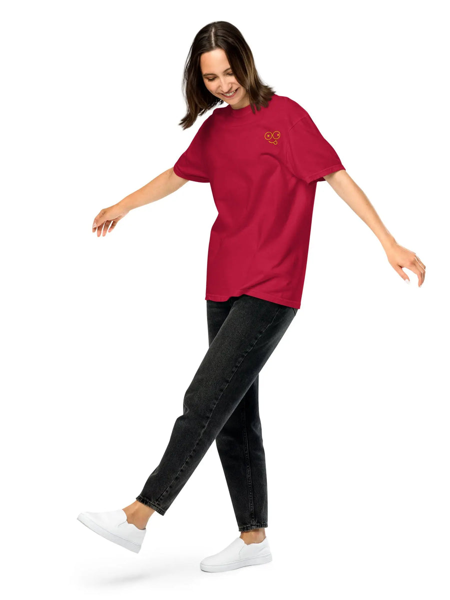 Model wearing a red garment-dyed unisex t-shirt with a small yellow glasses-face chest design