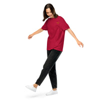 Model wearing a red garment-dyed unisex t-shirt with a small yellow glasses-face chest design