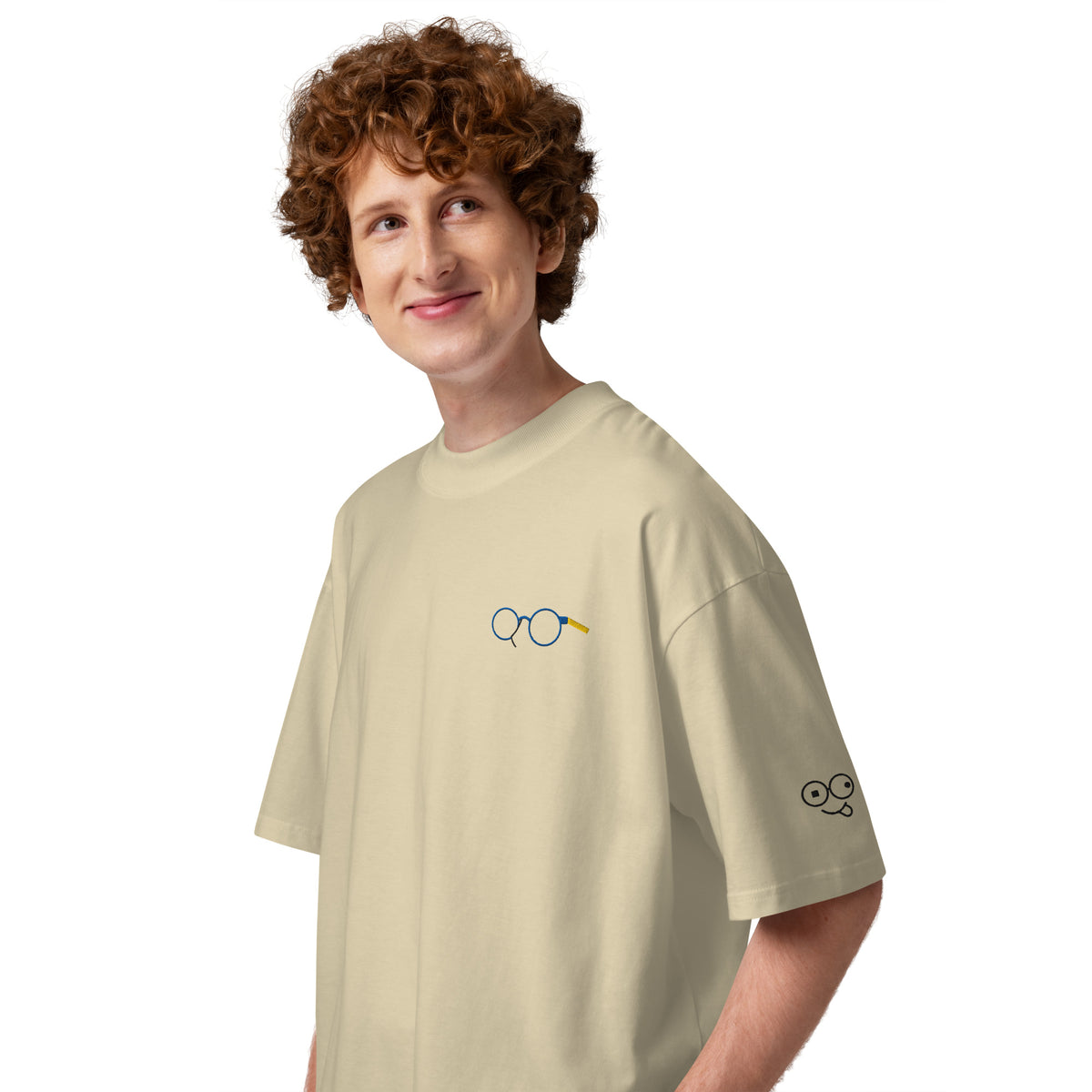 Angled view of stone oversized t-shirt showing glasses chest graphic and glasses-face sleeve design