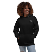 Model wearing a black pullover hoodie with a white glasses-face design and hands in the front pocket