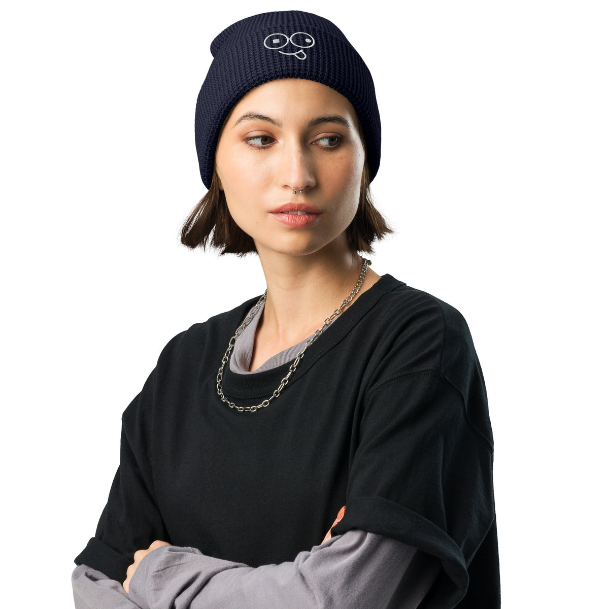 Model wearing a black waffle knit beanie with a folded cuff and white tongue-out glasses-face design