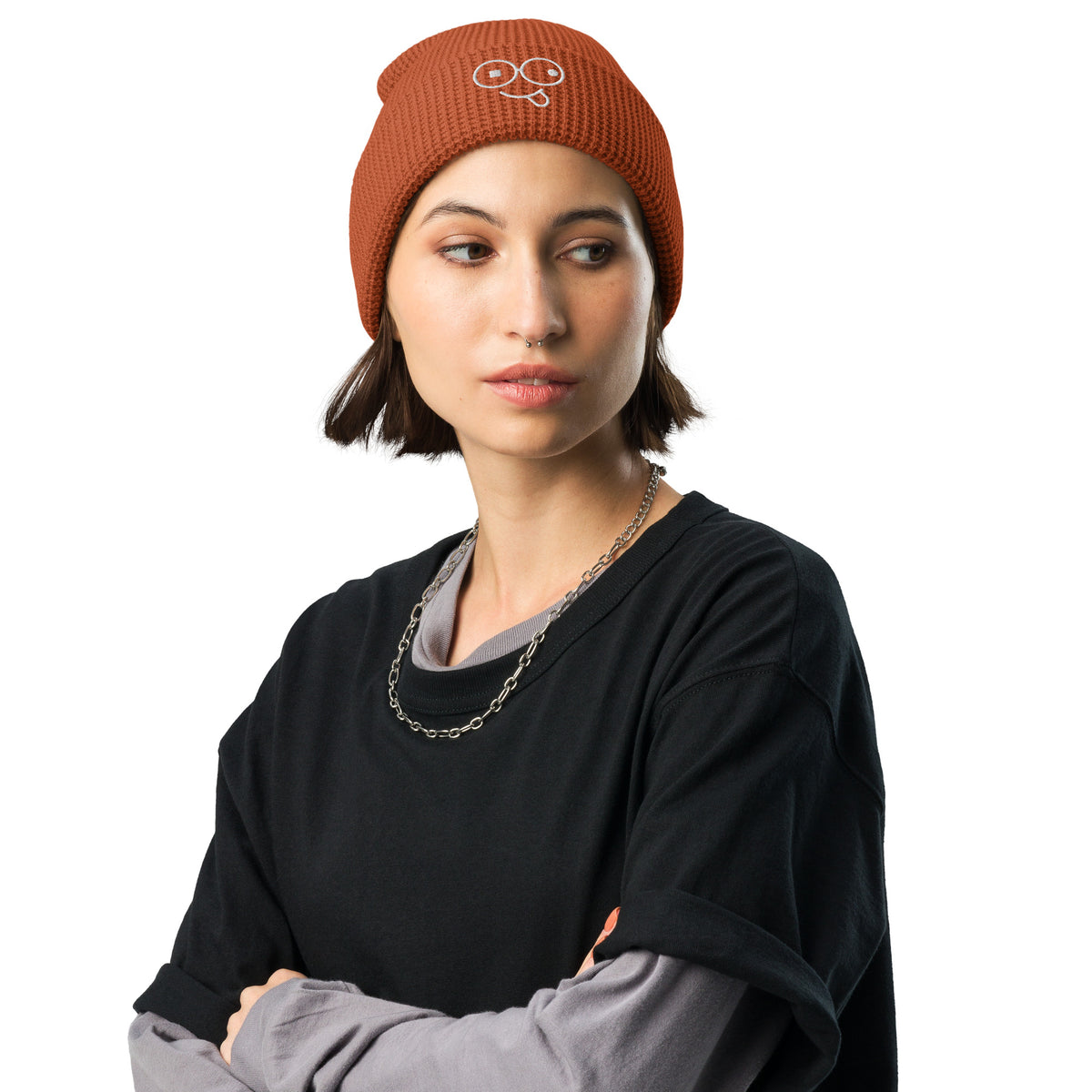 Model wearing a heather charcoal waffle knit beanie with a folded cuff and white tongue-out glasses-face design